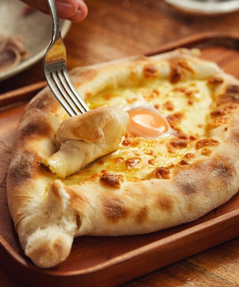 Adjarian Khachapuri ( Georgian traditional dish made of dough and different types of cheese with egg)